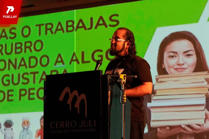 Ponente de Pukllay dando una charla frente a una pantalla